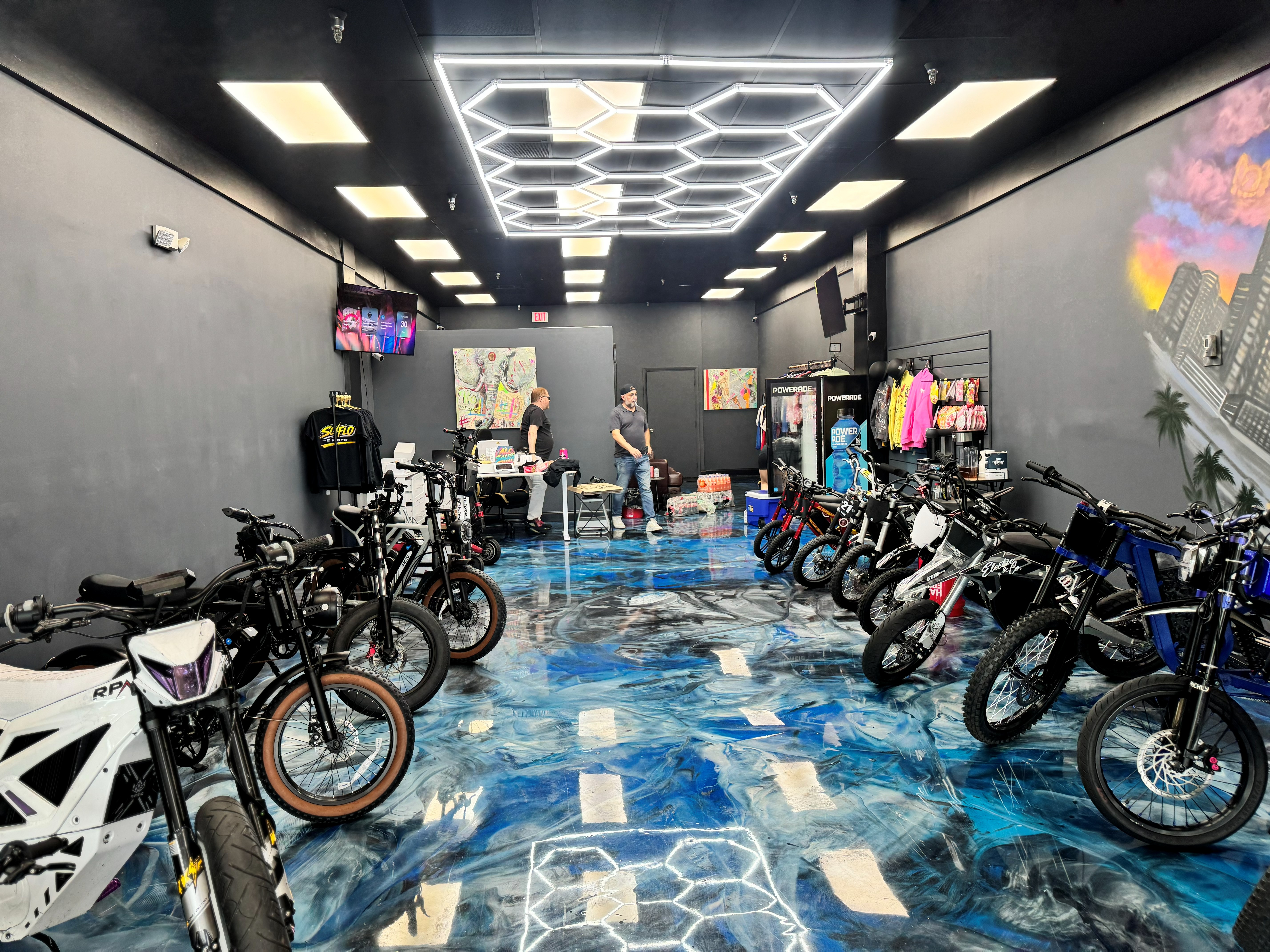 Wide interior view of the SoFlo E-Moto shop with bikes, merch, and the mural wall