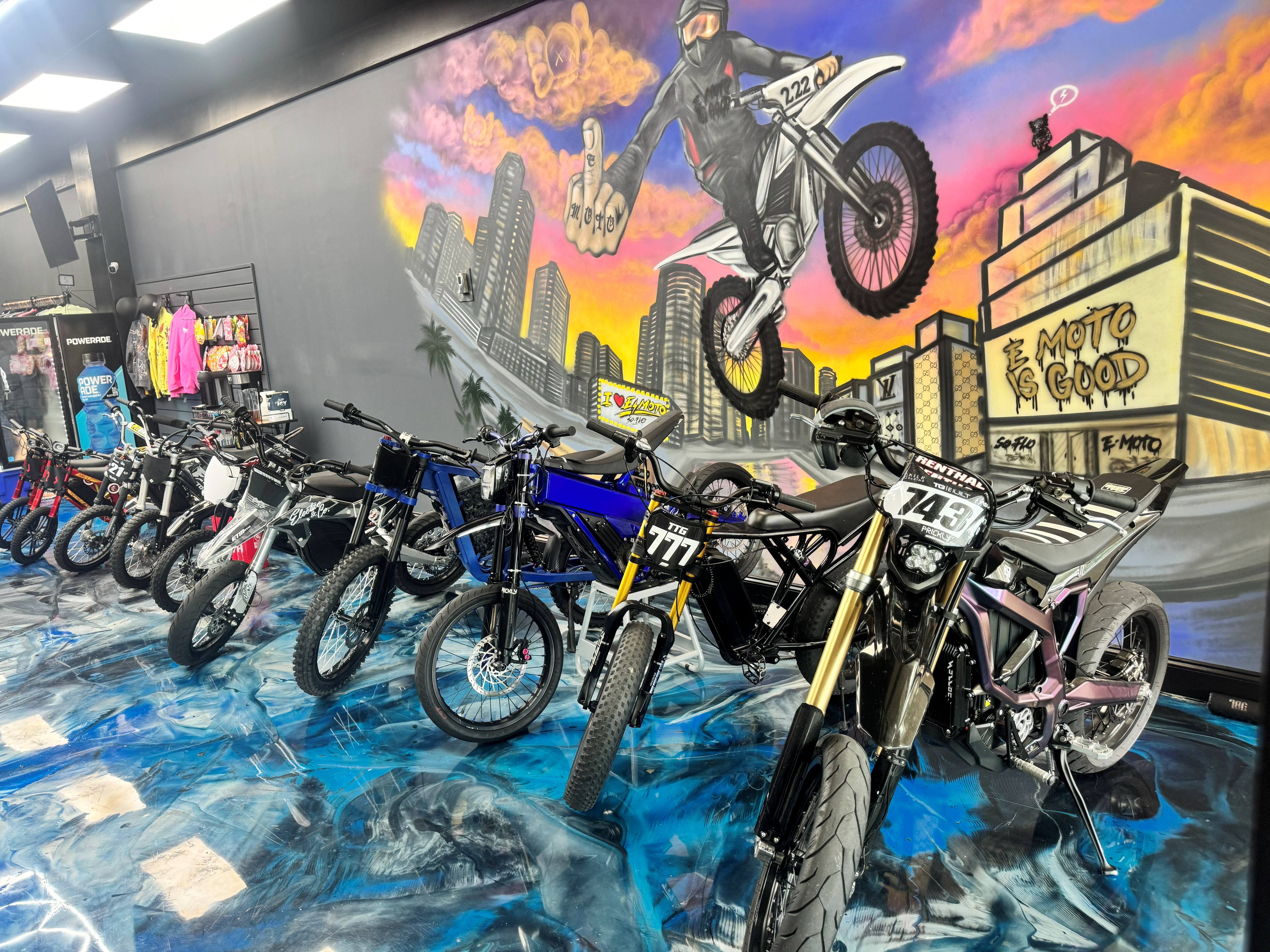 SoFlo E-Moto bike lineup in front of the mural wall inside the shop