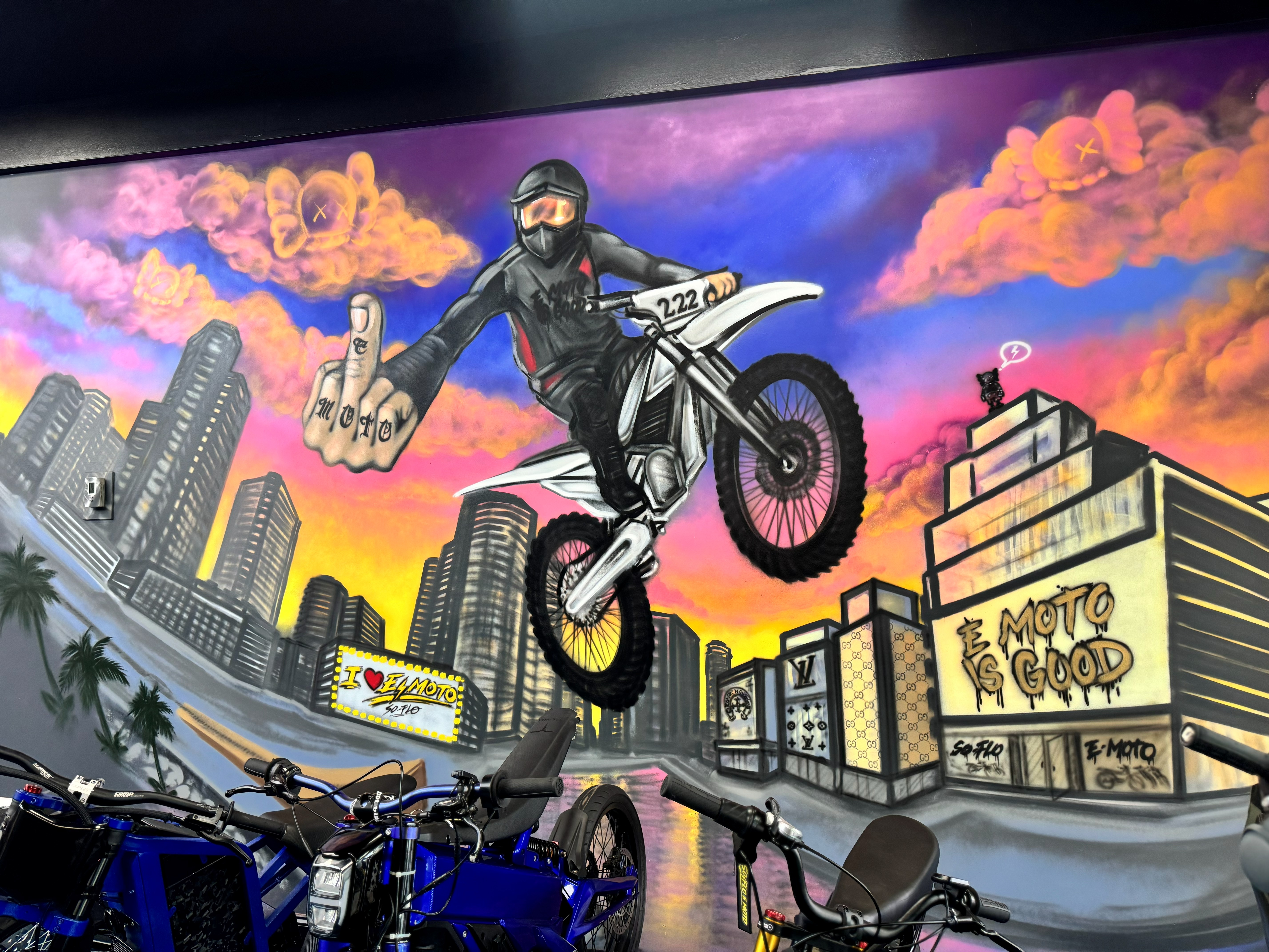 SoFlo E-Moto mural wall with a rider, skyline, and bikes inside the shop