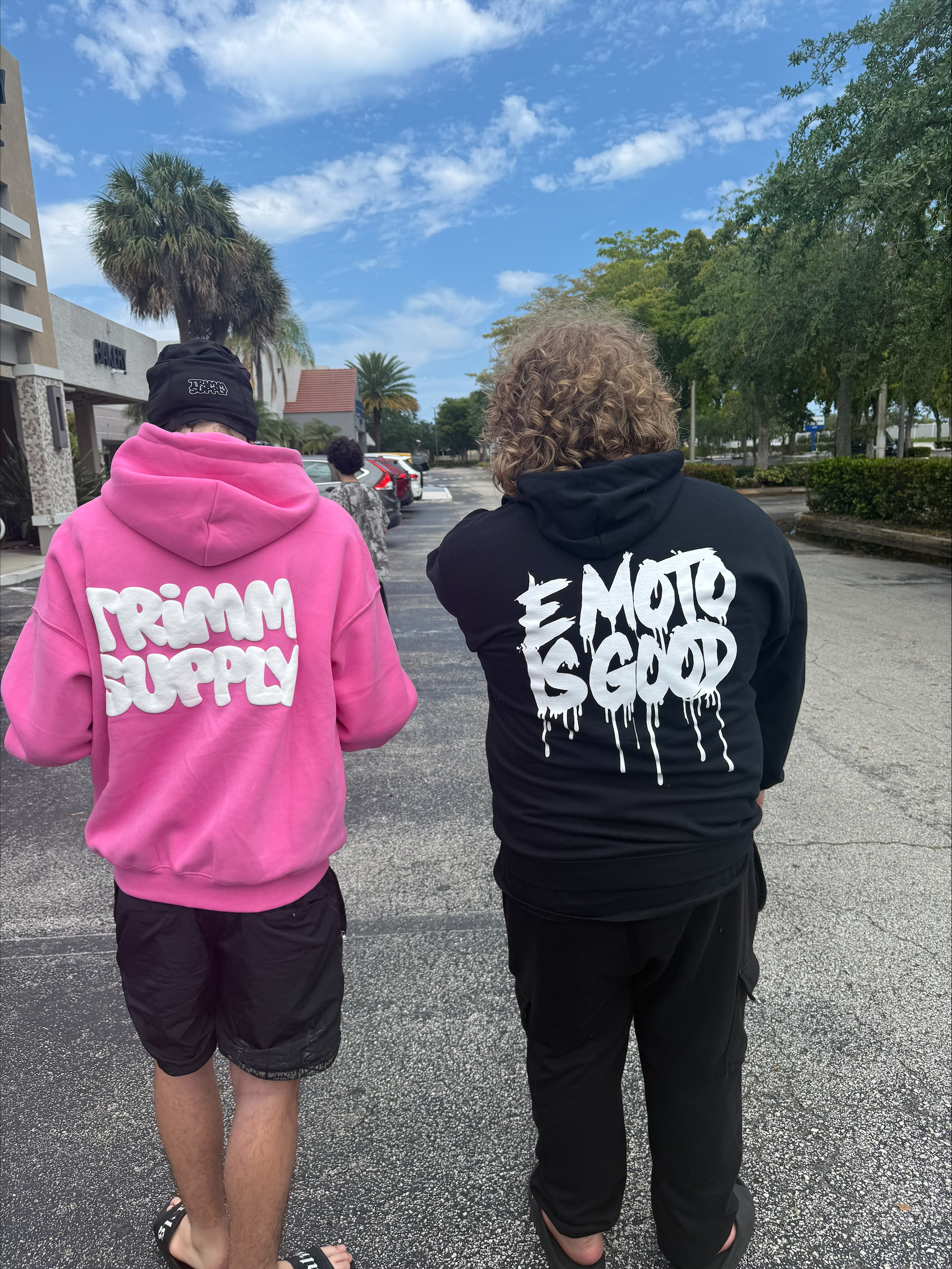 Two SoFlo E-Moto crew members walking outside in branded hoodies